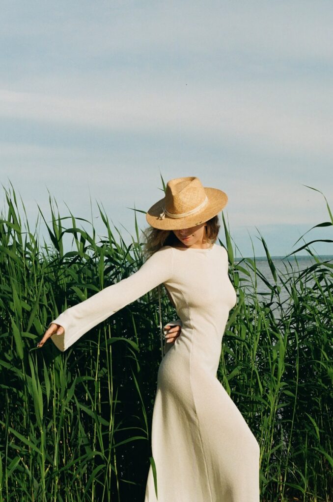 a woman in a long white dress and a hat